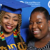 A graduate and friend pose for a photo at GradFest